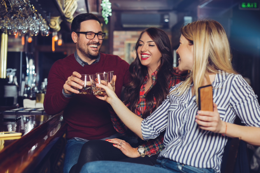 Tre personer tar ett glas i en bar